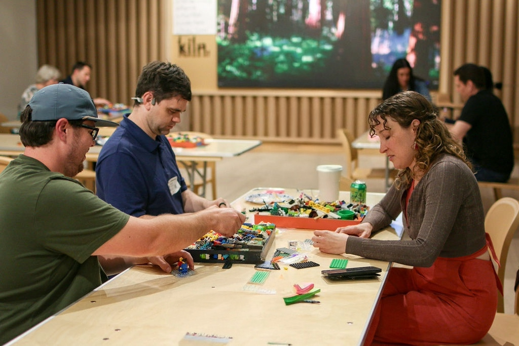 Attendees enjoying a collaborative LEGO building activity during a community event at Kiln coworking space in San Diego.